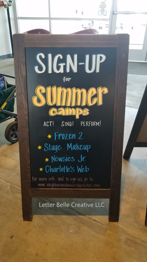 A-frame chalkboard promoting summer camps at Neighborhood Music at Stanley Marketplace: Frozen 2, Stage Makeup, Newsies Jr, and Charlotte's Web

Letter Belle Creative