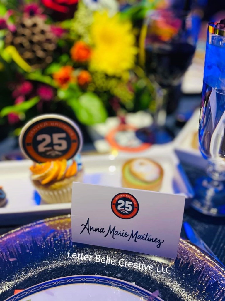 Denver Broncos 25th Anniversary Reunion Dinner for Super Bowl XXXII. White escort card with logo & name written in calligraphy, at place setting. October 2022

Letter Belle Creative